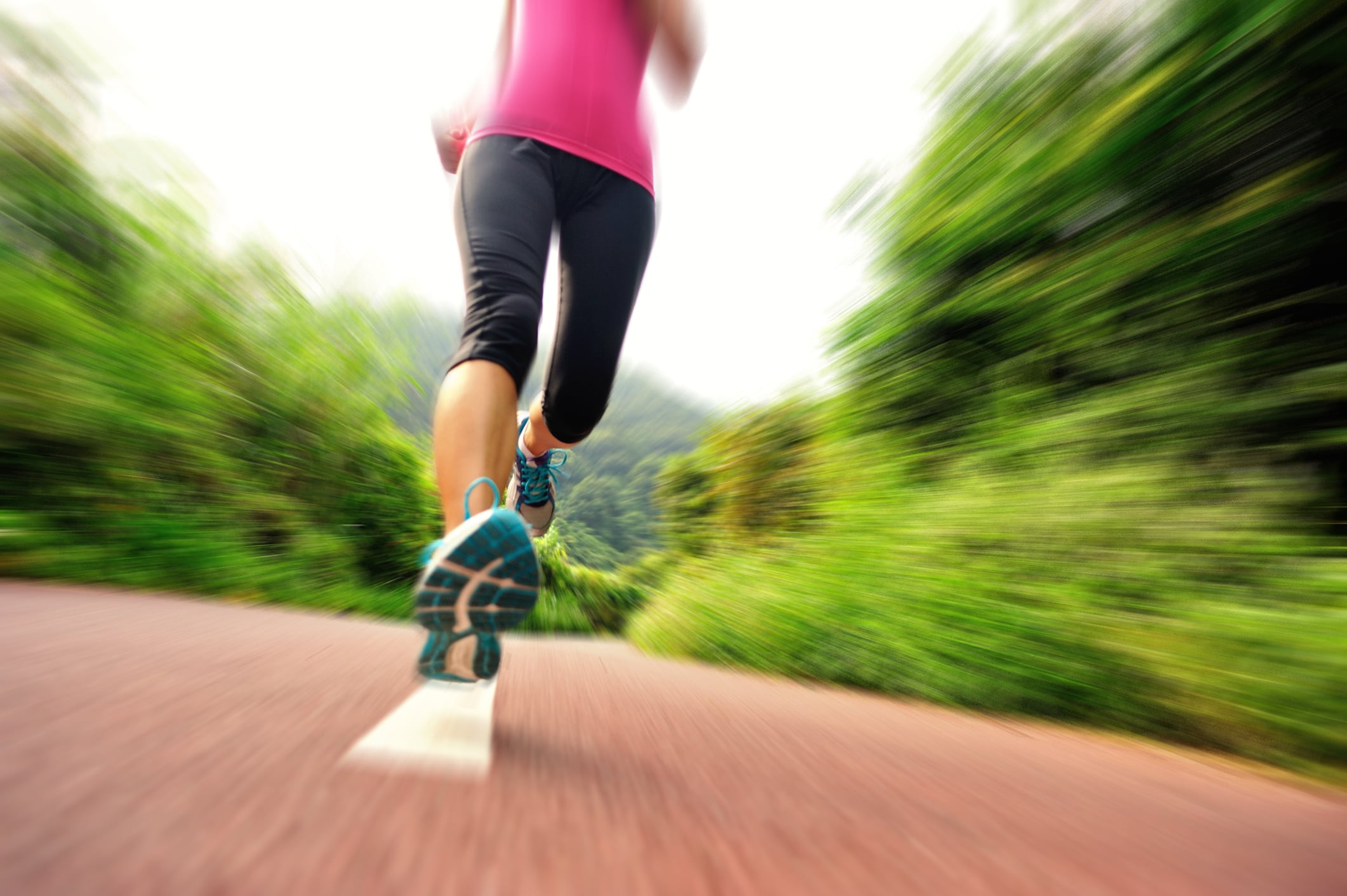 Runner athlete running on forest  trail. woman fitness jogging workout wellness concept.