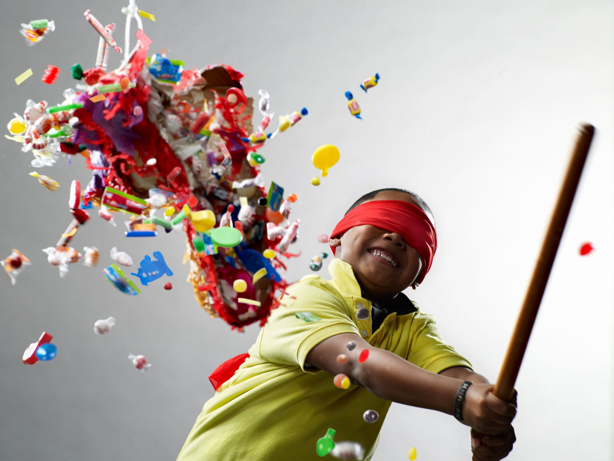 Image: boy hitting sweets from a toy