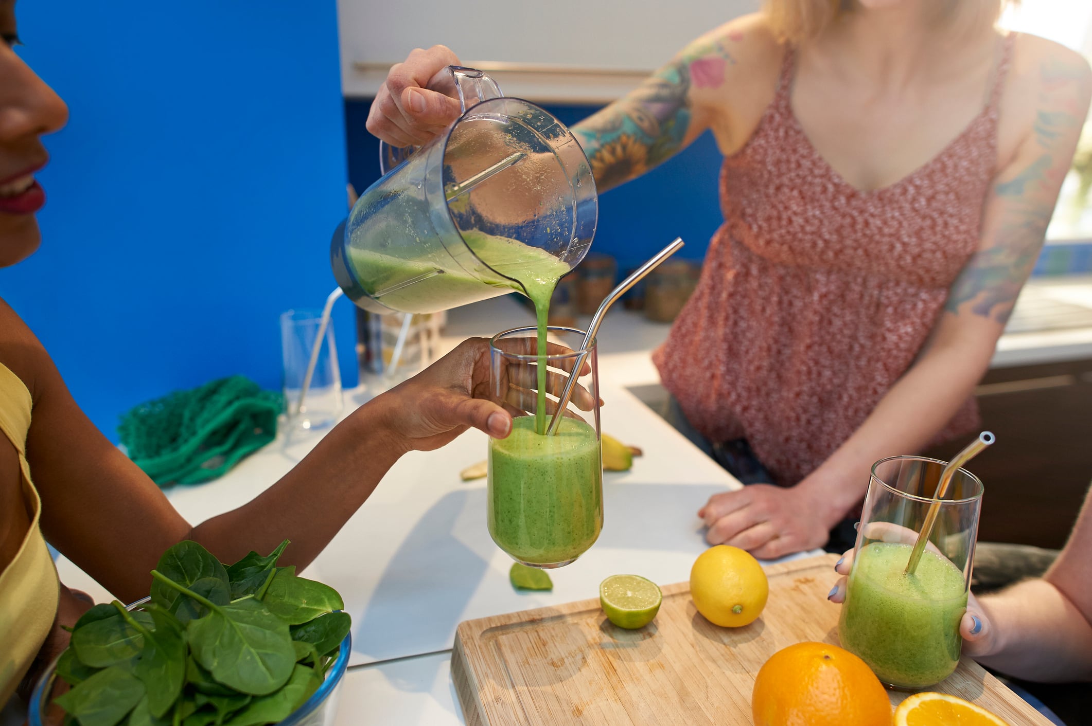 Friends make and share a plant based vegan smoothie in a plastic free kitchen.