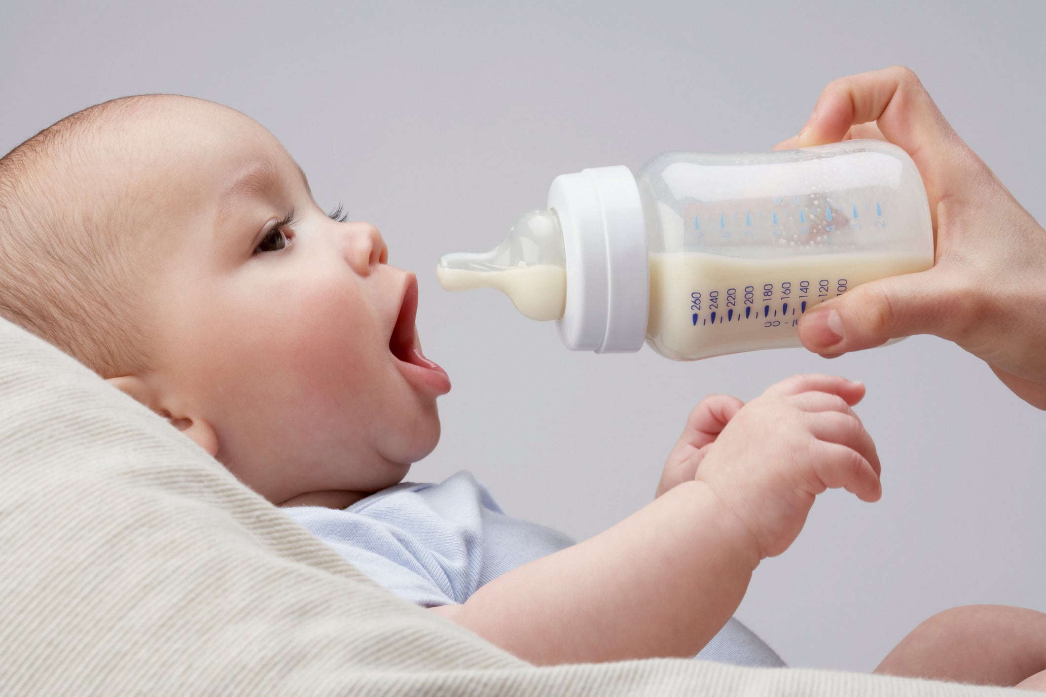 Baby with milk bottle in mother's hand