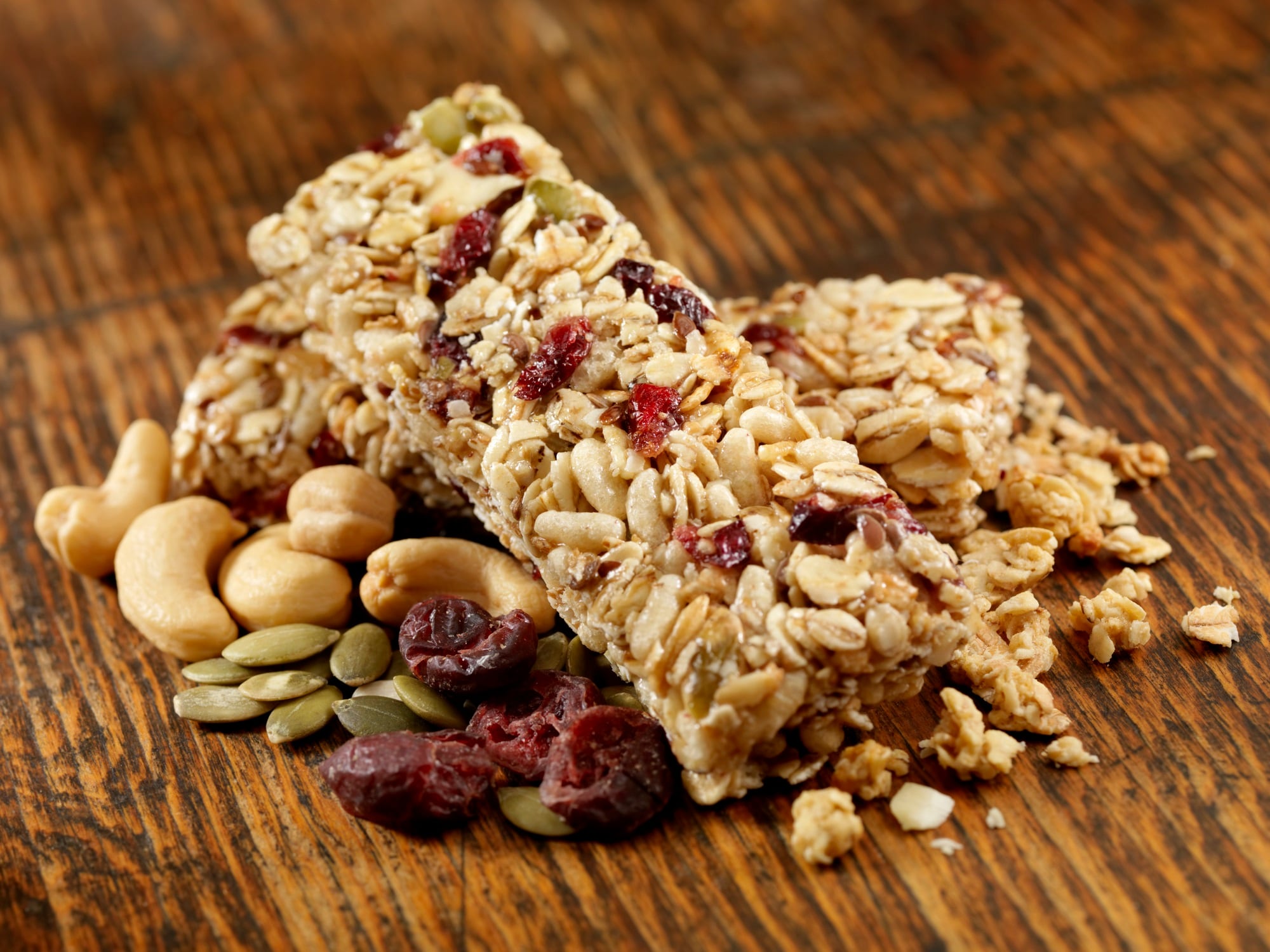 Granola Bars with Mixed Nuts and Cranberries on an Old Wood Table -Photographed on Hasselblad H3D2-39mb Camera