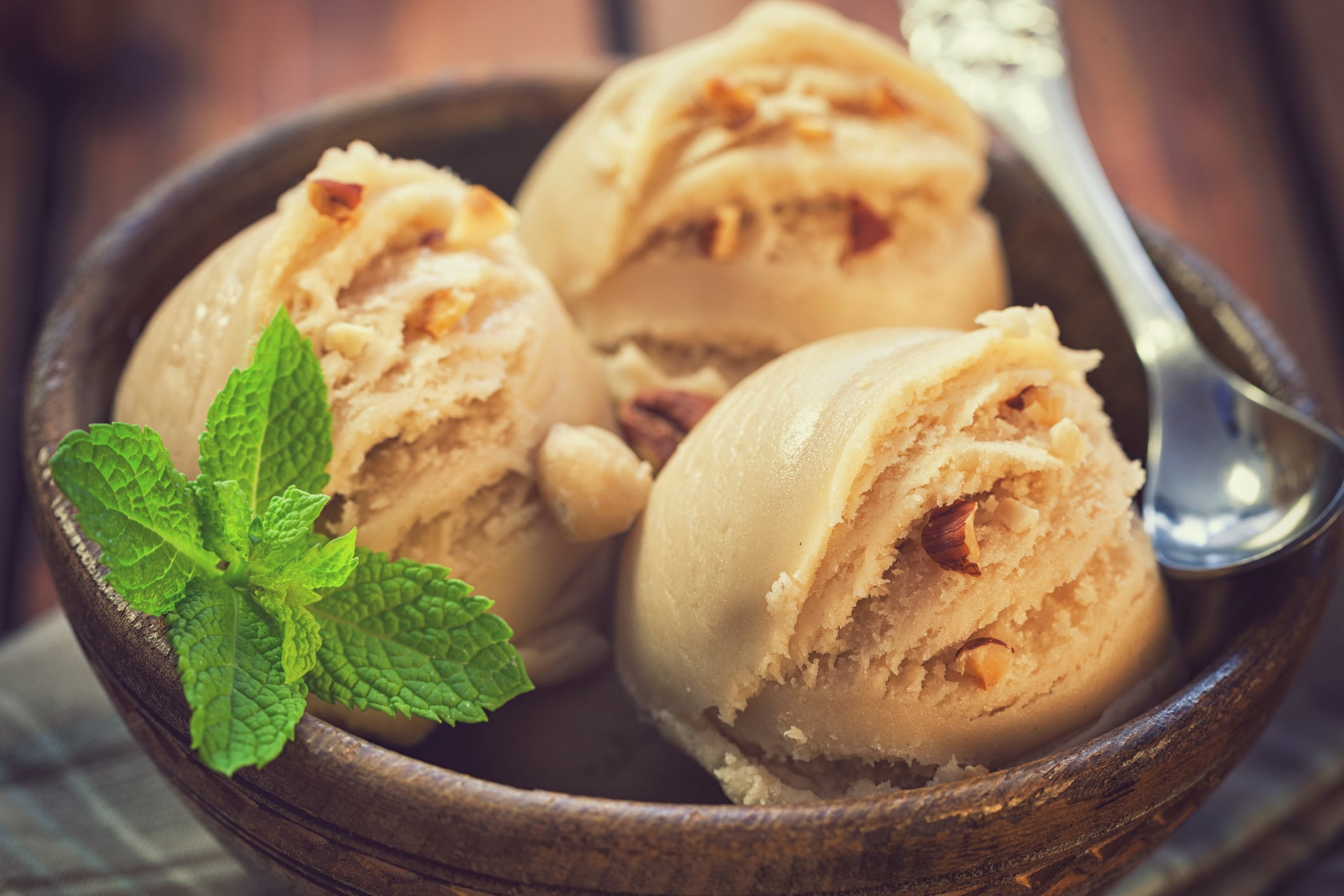 Homemade chocolate ice cream with nuts and mint served in bowl on the old wooden background