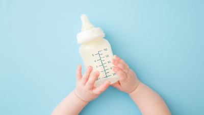 A baby holding a milk bottle.  ©Getty Images 